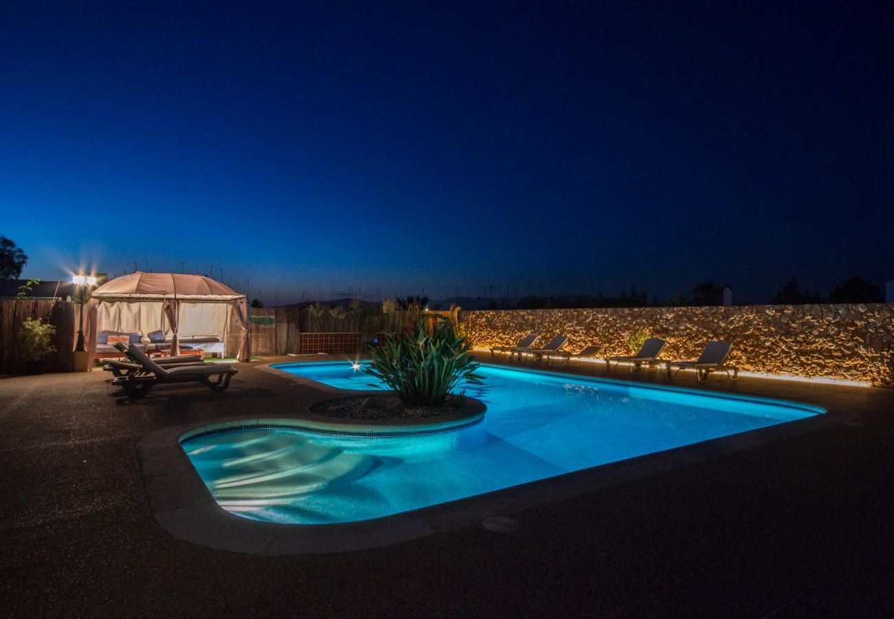 La piscine de Can Lucia illuminée la nuit, un endroit idéal pour se détendre.